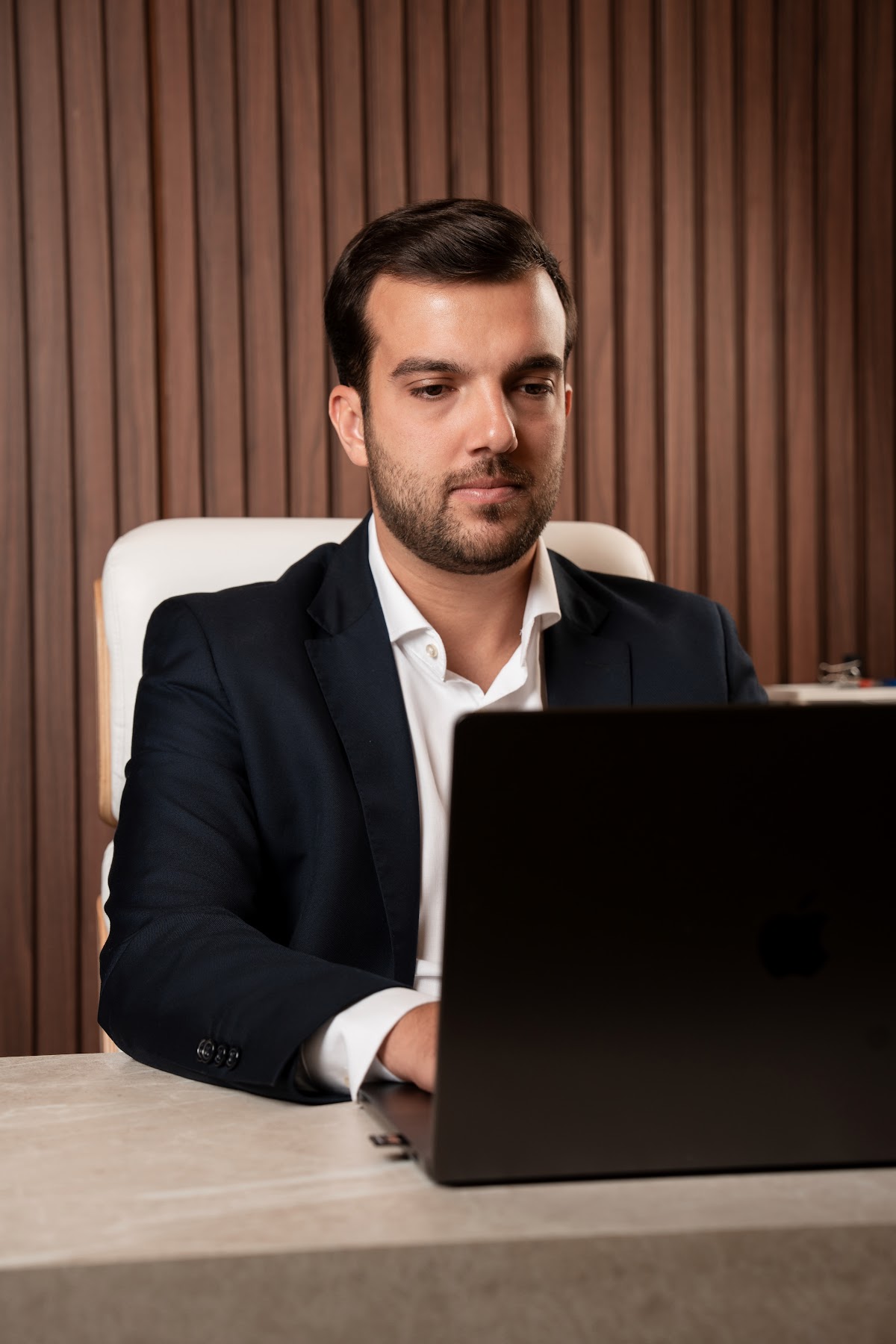 Dr. João Pedro Carvalho trabalhando no computador em seu consultório
